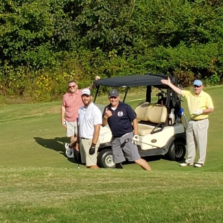 Golfers on golf course around golf cart